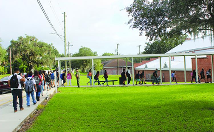 Students at Miller Middle School spread out as they enter school Monday morning.