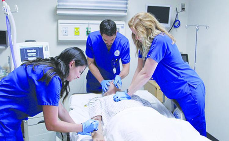 St. Johns River State College respiratory care students Lacy Smith, Robert Kerr and Amber Walters work on resuscitating the program’s computerized mannequin during their lab in 2019.