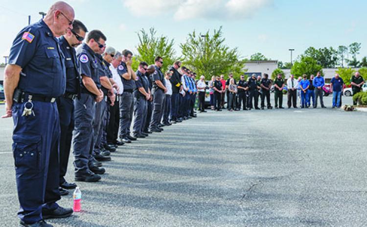 Uniformed personnel bow their heads in prayer to begin the 9/11 remembrance ceremony last year.