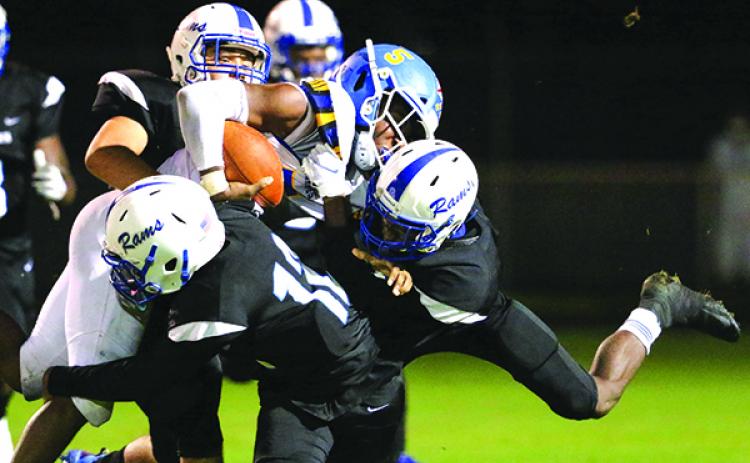 Interlachen defenders Justin Herring (12) and John Servin (front) stop Fernandina Beach running back Khamari Barksdale on a short gain in the first half. (GREG OYSTER / Special To The Daily News)