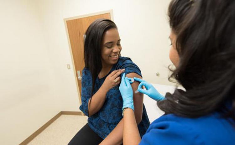 A health care provider places a bandage on the injection site of a patient who received an influenza vaccine. The Centers for Disease Control and Prevention recommends everyone 6 months of age and older get a flu vaccine every year.