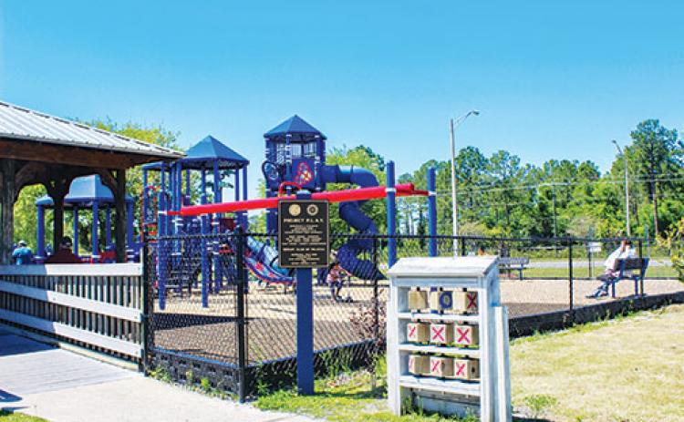 Children and families relax at Project P.L.A.Y. in Palatka on Friday but no one sets foot on the splash pad that reopened the same morning due to the 60-degree weather.