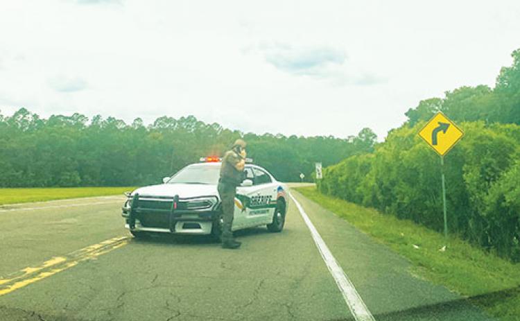 A Putnam County Sheriff’s Office deputy blocks County Road 310 on Thursday after a fatal vehcile overturned 4 miles down the road.