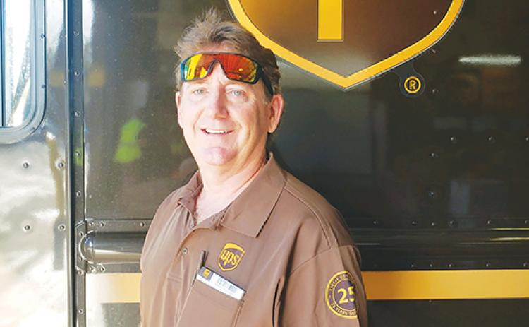 UPS driver Nick Johnson, who has a 25-year safe driving record, stands in front of his truck before his Palatka route.