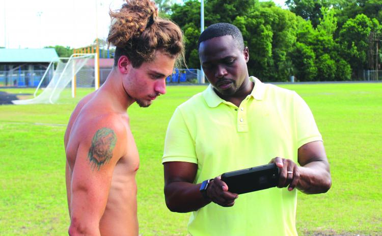 Palatka High senior hurdler Seager Jordan goes over his form on video with head track coach Jarimy Passmore during practice Wednesday. (MARK BLUMENTHAL / Palatka Daily News)