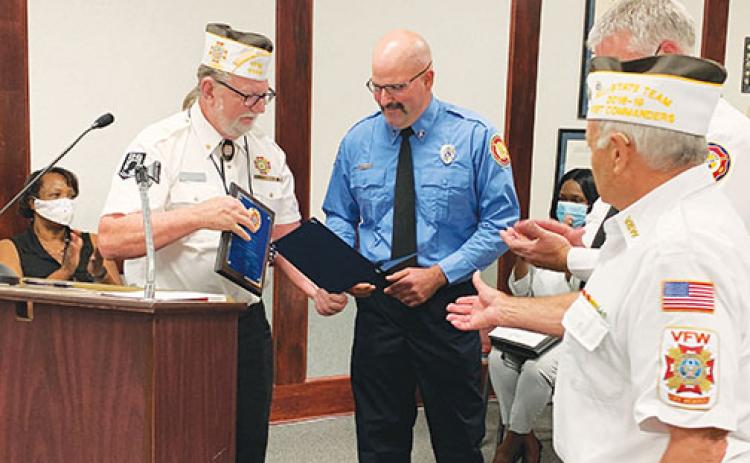 Palatka Fire Department Engineer David Zimmer, center, receives the Firefighter of the Year award from Veterans of Foreign Wars Post 3349 Quartermaster Gerald Shuler, left, and Commander Gerald Donnelly, right.
