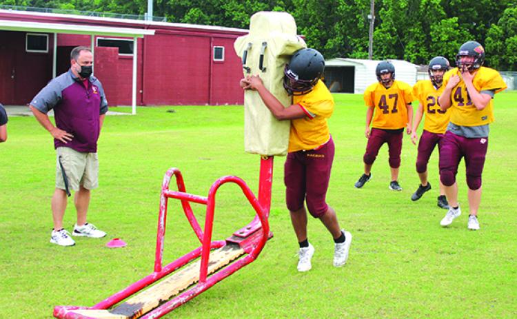 Crescent City High School football coach Sean Delaney (left) watches players go through a tackling dummy drill during practice last week. The Raiders host Daytona Beach Father Lopez tonight. (MARK BLUMENTHAL / Palatka Daily News)
