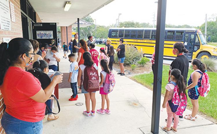 Parents and students make their way to classrooms at Middleton-Burney Elementary School on the first day of the 2020-2021 school year.