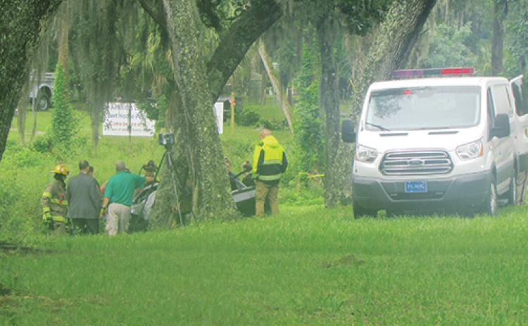 Law enforcement officials and emergency responders work the fatal crash scene off Crill Avenue in Palatka on Friday morning.