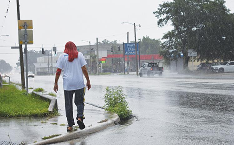 A local man traverses down Reid Street in Palatka as Tropical Storm Elsa lashes Putnam County on Wednesday.