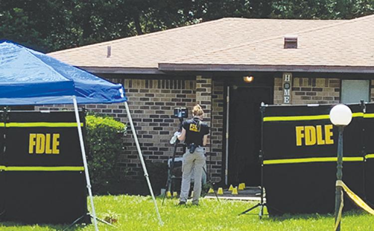 A Florida Department of Law Enforcement technician works the site of a fatal shooting in Crescent City.