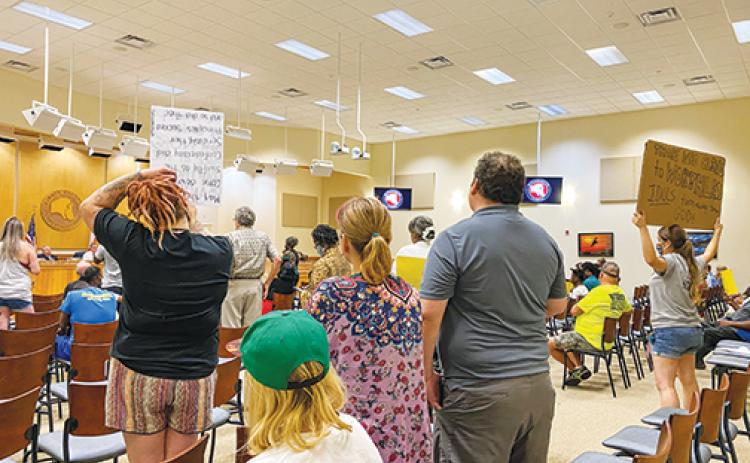 Putnam County residents hold signs during a Board of County Commissioners workshop Tuesday advocating for the Confederate monument’s removal from the Putnam County Courthouse.