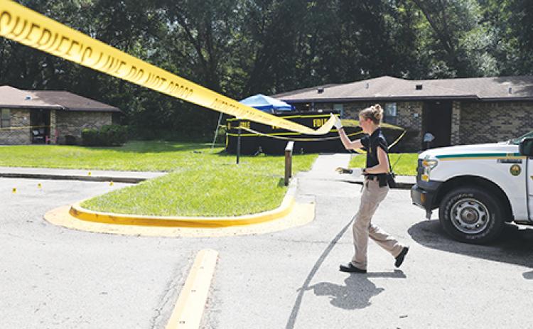 An investigator works the scene of a fatal shooting Tuesday in Crescent City.
