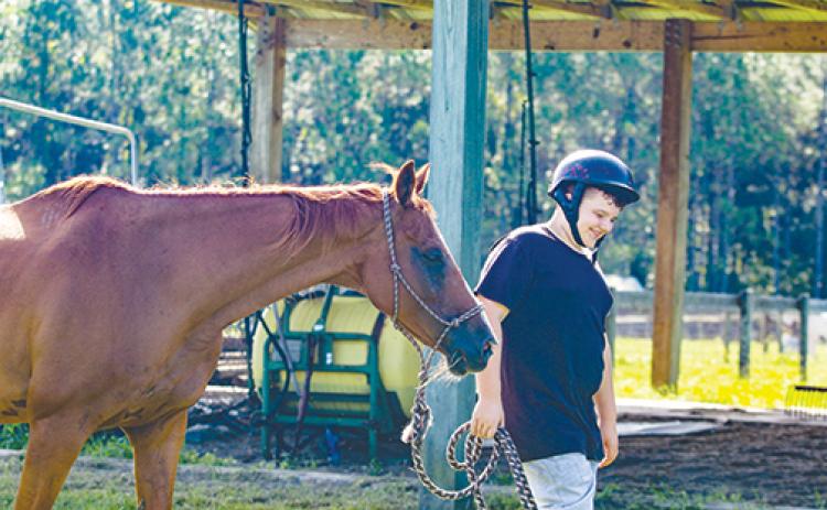 Jonathan Hall, 14, leads his horse, Trooper, to a pen at Rodeheaver Boys Ranch to train the 1,300-pound thoroughbred as part of the ranch’s new vocational program.