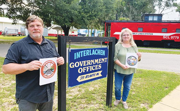 Interlachen seal contest winner Ted Burke and finalist Esme Coward hold their designs in front of Interlachen Town Hall. 
