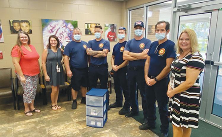 Palatka Fire Department employees donate school supplies to Mosley Elementary School on Thursday before going to three other elementary schools.