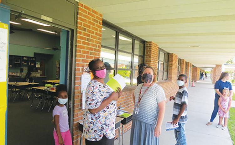 Students and employees at Ochwilla Elementary School wear masks on the first day of the academic year.