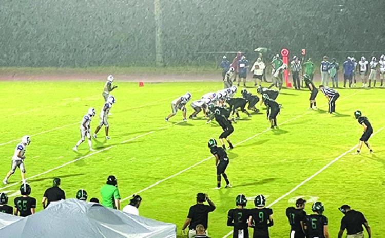 Interlachen Jr.-Sr. High quarterback Reggie Allen Jr. (top left) calls signals for his offense during a pounding rainstorm in the second quarter Friday night against host Daytona Beach Father Lopez. (TYLER JARNIGAN / Special to the Daily News)
