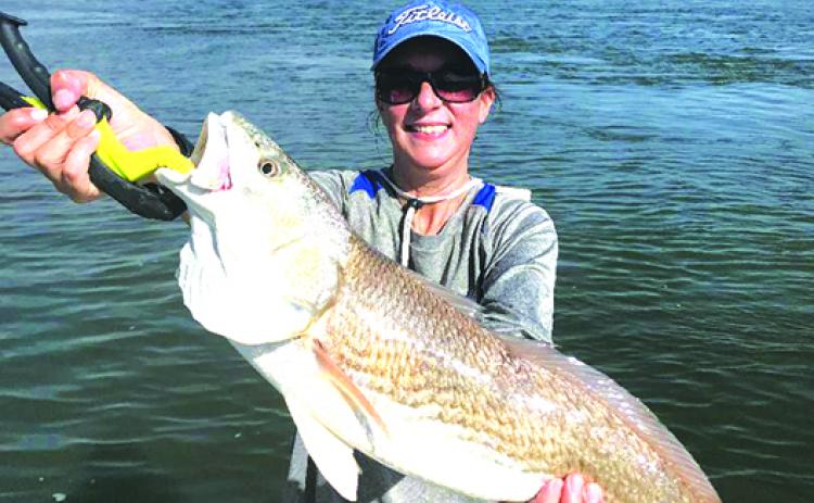 Ana Heartz holds up her 37-inch redfish before  releasing back into the waters recently. (GREG WALKER / Daily News correspondent)