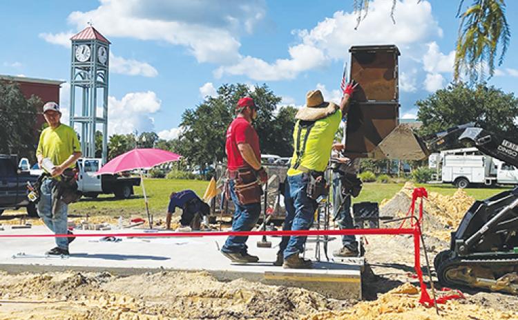 Workmen from Wilkinson Family Construction place a column support in place at the new Palatka amphitheater under construction on the riverfront near the Millennium Clock Tower.