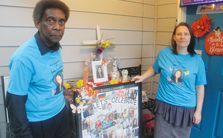 Robert and Melanie Belton stand in front of the vigil they created to honor their daughter, Ayana Grace Belton, who was a victim of domestic violence and was fatally stabbed in 2020..