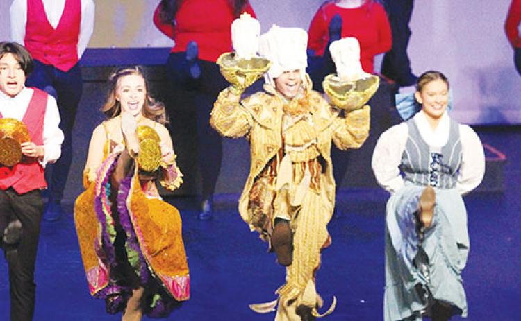 Timothy Lake (center, as Lumiere) and Megan Lingle (right, as Belle) and ensemble cast members perform “Be Our Guest” from Disney’s Beauty and the Beast as part of the revue show, “All Together Now!”