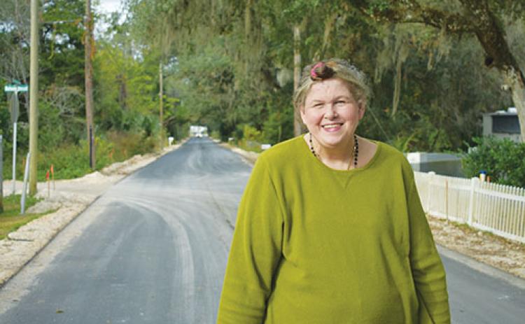 Sandra Lee Harvey stands on Bainbridge Road in front of her Palatka home. The road was paved in October, and nearby roads are slated to be paved starting next month.