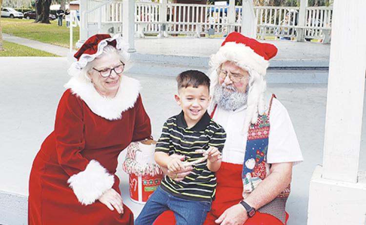 A child sits in Santa Claus’ lap as he tells Santa and Mrs. Claus what he wants for Christmas during Crescent City’s 2019 holiday celebration.