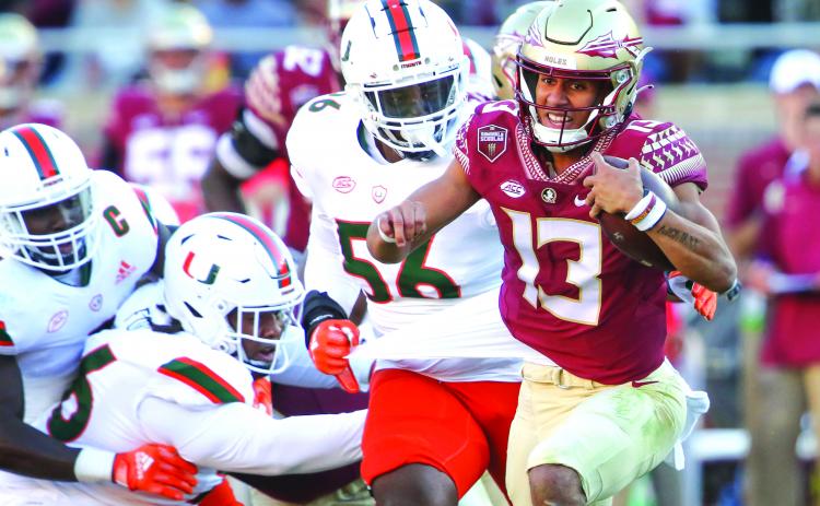 Florida State’s Jordan Travis (13) escapes away from Miami’s Leonard Taylor during the Seminoles’ victory over the Hurricanes on Nov. 13. (GREG OYSTER/Palatka Daily News)