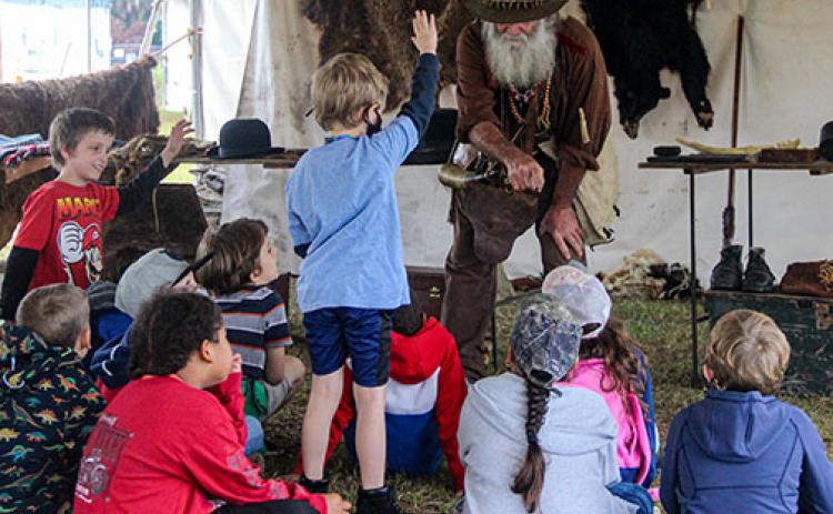 A living history actor portraying trader Job Wiggens shows Putnam County students how to make a fire during the Bartram Frolic at the Palatka riverfront. 