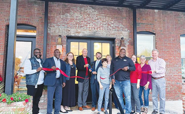 Palatka city officials and building owner Charlie Douglas, fifth from left, celebrate Douglas Law Firm’s new location on Second Street with a ribbon-cutting this week. 