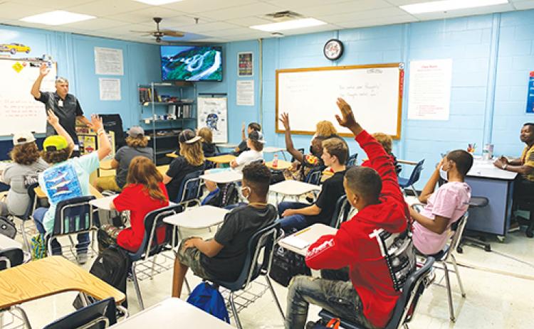 Students at Palatka Junior-Senior High School raise their hands to answer a question during the first day of school in August 2021.