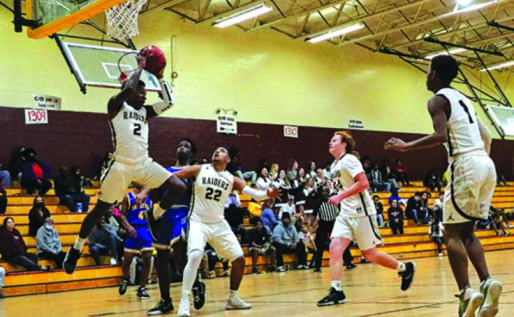 Crescent City’s Naykeem Scott goes high for a rebound against Palatka as teammate Robert Johnson (22) boxes out Tuesday night. (RITA FULLERTON / Special to the Daily News)