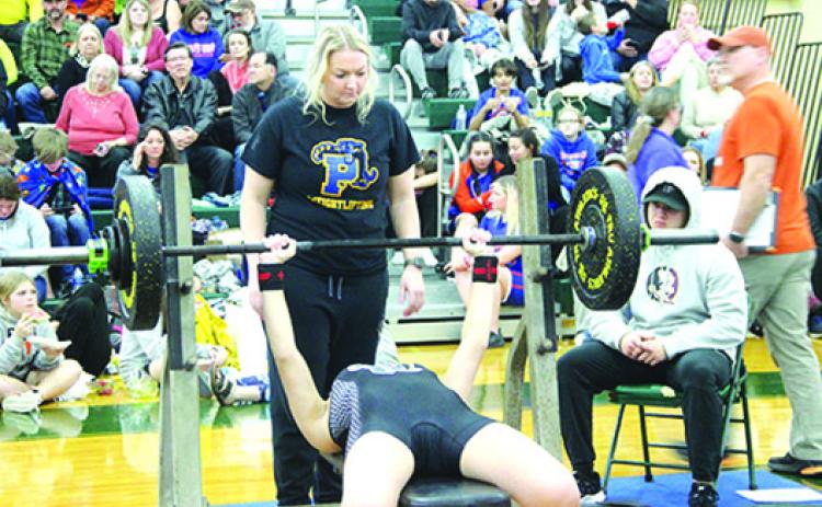 Palatka Junior-Senior High School girls weightlifting coach Katelynn Smith spots one of her lfiters at Saturday’s Region 2-1A championship. (COREY DAVIS / Palatka Daily News)