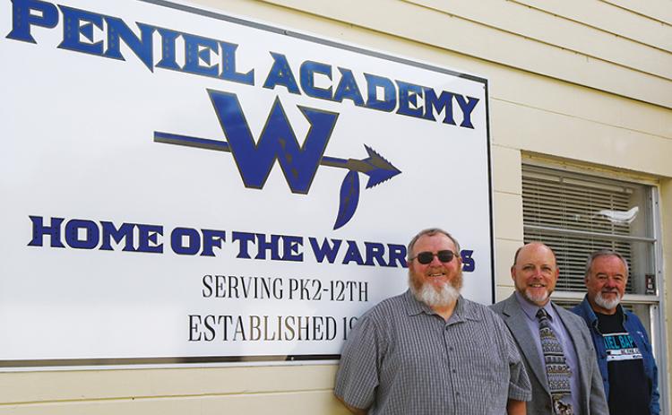 Peniel Academy’s middle school history and Bible teacher Robert Massey stands next to school Administrator Bill Evans and Peniel Baptist Church Senior Pastor Benny Reynolds outside the Palatka school Tuesday.