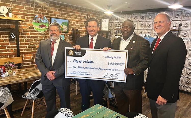 From left, Palatka City Manager Don Holmes, Gov. Ron DeSantis, Palatka Mayor Terrill Hill and Rep. Bobby Payne pose for a photo in Madison, Fla., with a ceremonial check from the state for infrastructure funds.
