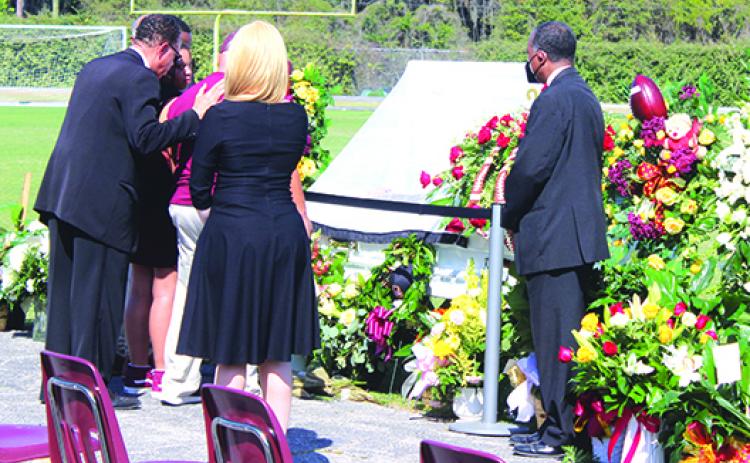  Karl Flagg embraces Clarence “Pooh Bear” Williams’ daughter, Jordan Williams (left), and close friend Wes Thompson in front of the casket before Saturday’s service. (MARK BLUMENTHAL / Palatka Daily News)