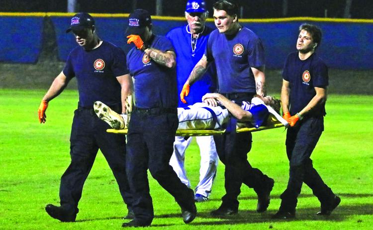 Palatka head baseball coach Sam Rick (center) watches paramedics take Panthers player Jonathan Germany off the field during the fourth inning of Friday night’s county tournament final. (RITA FULLERTON / Special to the Daily News)