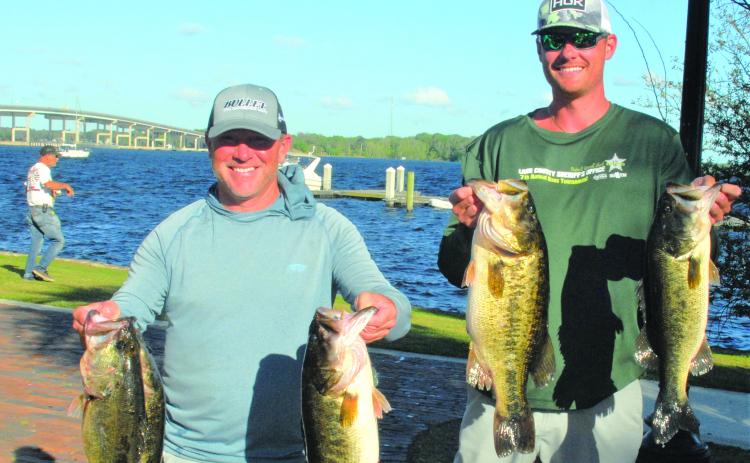 Jason Caldwell and Tyler Deruiter of Jacksonville  hold up their winning fish in the Xtreme Bass Trails at the Palatka Riverfront. (GREG WALKER / Daily News correspondent)