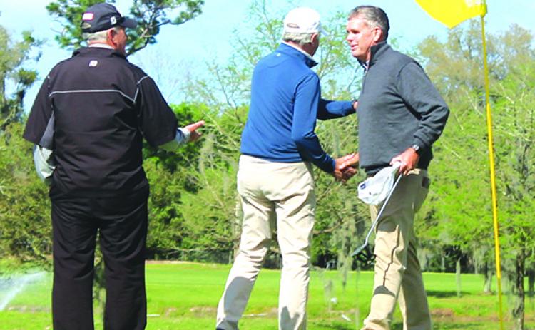 Rusty Strawn (right) of McDonough, Georgia, receives congratulations after sinking a birdie putt to win a playoff at the Senior Azalea Amateur title on Sunday. (MARK BLUMENTHAL / Palatka Daily News)