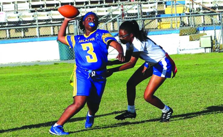 Palatka quarterback Chloe Dasher avoids the flag pull of a Jacksonville Wolfson defender and gets a pass off during Monday’s play-in game at home. (RITA FULLERTON / Special to the Daily News)