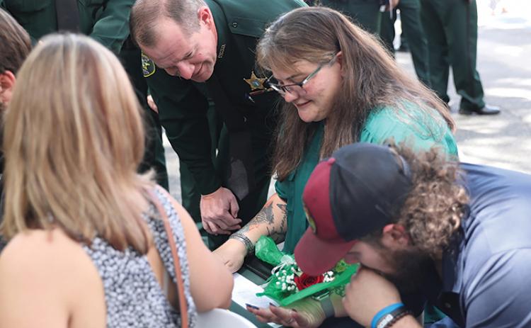 Putnam County Sheriff Gator DeLoach looks with Lachrisha Elam, the widow of sheriff’s office Capt. Mark Elam, and her family as her husband was recognized Monday by the Florida Sheriff’s Association.