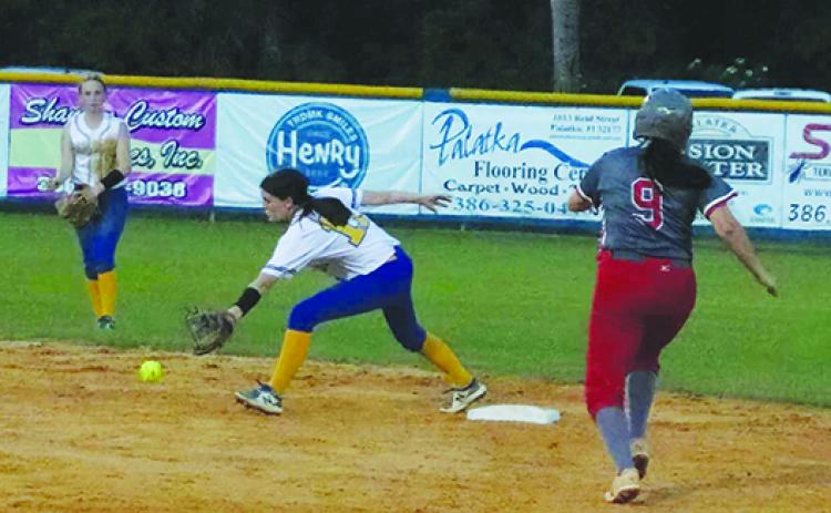 Palatka second baseman Whitney Seebacher reaches for the ball as Alachua Santa Fe’s Maddie Martin heads to second base with a fourth-inning double Tuesday night. (RITA FULLERTON / Special to the Daily News)