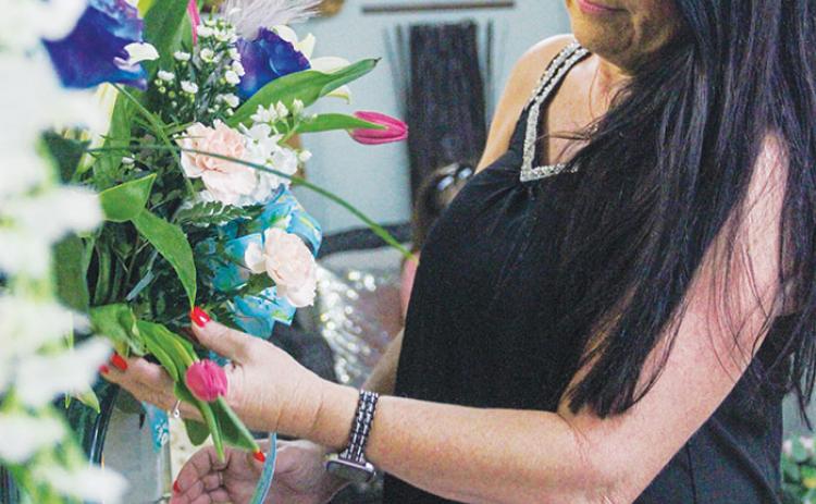 Kim Singletary, owner of Palm Florist in Palatka, perfects one of the shop’s Mother’s Day bouquets Thursday.