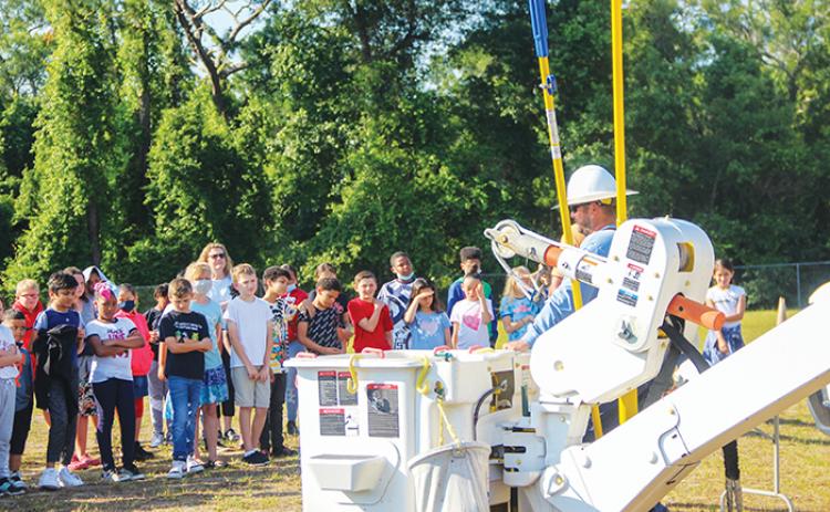 Ochwilla Elementary School students watch a demonstration by a Clay Electric Cooperative employee Tuesday during the school’s career day.