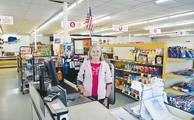 Cashier Denise Mason stands beside her cash register at Williamson's Food Store Wednesday.