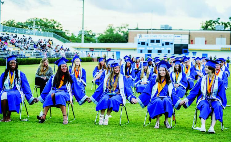 Photo courtesy of the Putnam County School District. Q.I. Roberts Junior-Senior High School seniors hold hands before graduating earlier this month. 