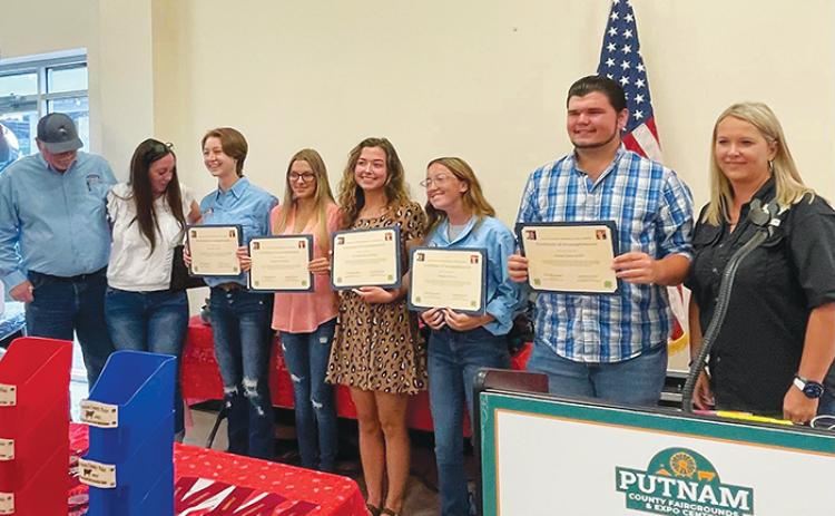 The five winners of the Logan Gaylord Memorial Scholarship stand together Monday at the Putnam County Fairgrounds.