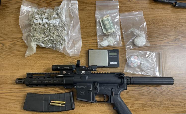A semi-automatic rifle and seized drugs from a northside traffic stop Tuesday sit on a table.