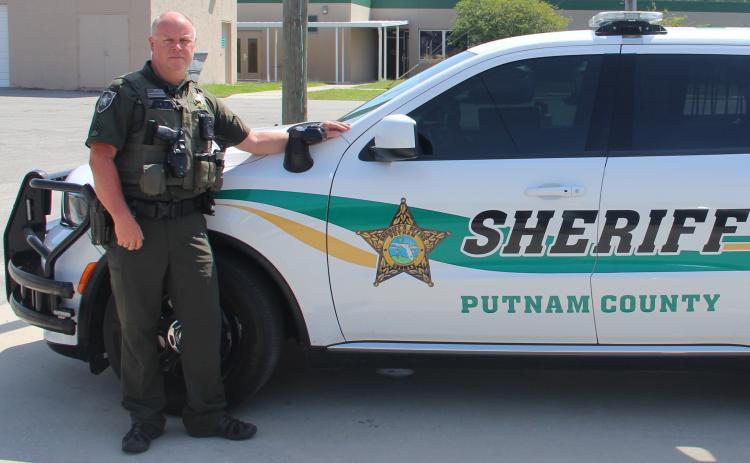 Sgt. Shannon DePew, one of the first Putnam County sheriff's deputies to receive a body camera, stands beside his patrol car Tuesday morning. The camera is in the upper left pocket of his bulletproof vest.